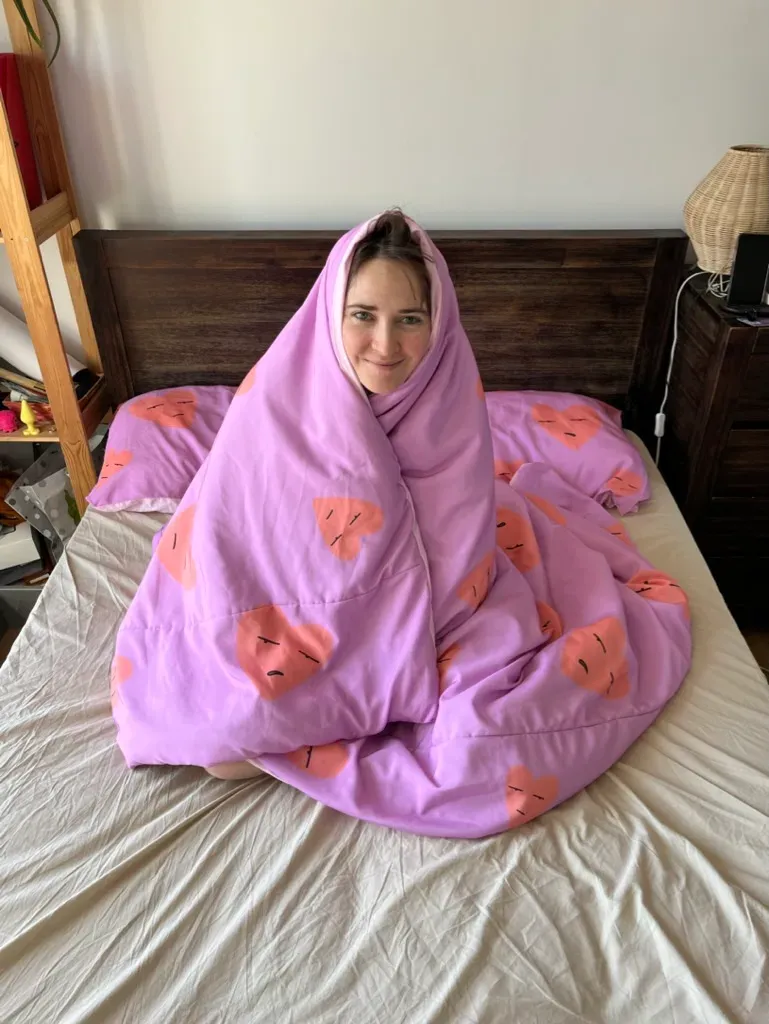 Ana wrapped up in the Grumpy Hearts duvet.